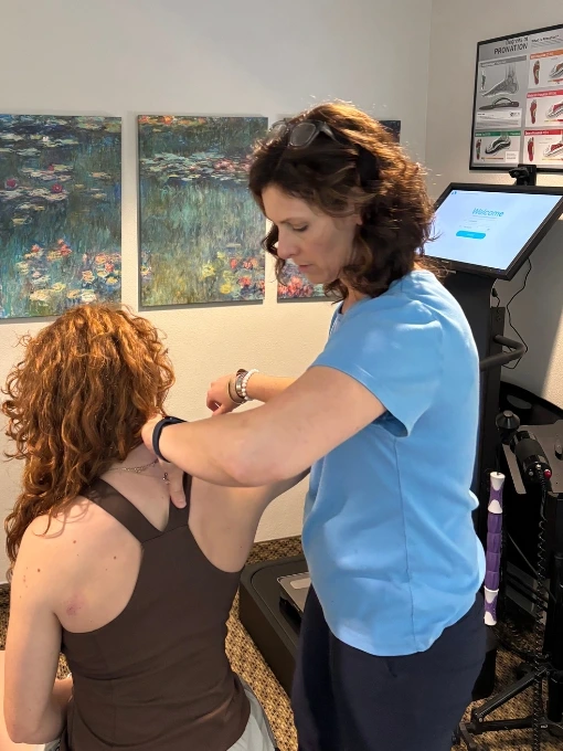 Dr. Fawn Ray performing myofascial shoulder therapy on a patient at her Colleyville chiropractic clinic