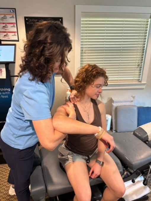 Dr. Fawn Ray performing myofascial release therapy on a female patient’s shoulder