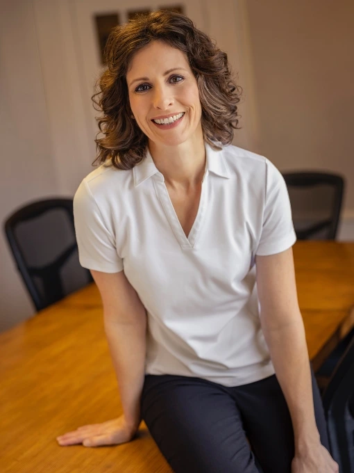Professional headshot of Dr. Fawn Ray, chiropractor in Colleyville, TX, at the conference room table
